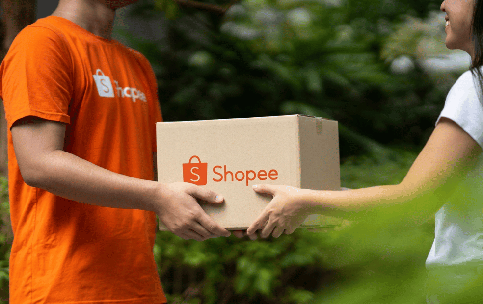 Entregador Shopee entregando uma caixa para uma cliente